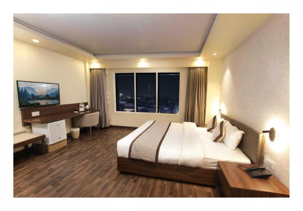 - une chambre avec un lit, un bureau et une fenêtre dans l'établissement Gorakha Hotel Pvt Ltd, à Itahari