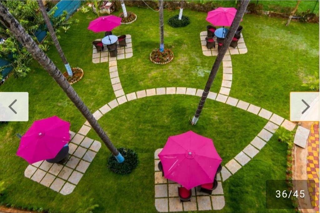 een uitzicht over een park met roze parasols bij The Southern Soul Beach Resort, Goa in Goa
