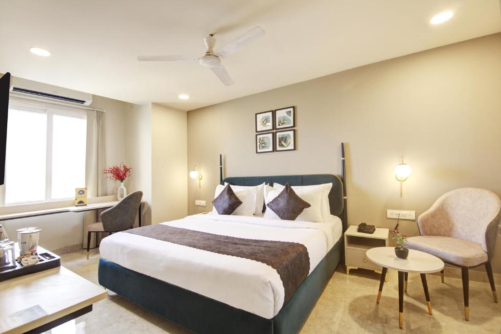 une chambre d'hôtel avec un lit et une chaise dans l'établissement Saltstayz Horizon - Golf Course Road & Sector 29, à Gurgaon