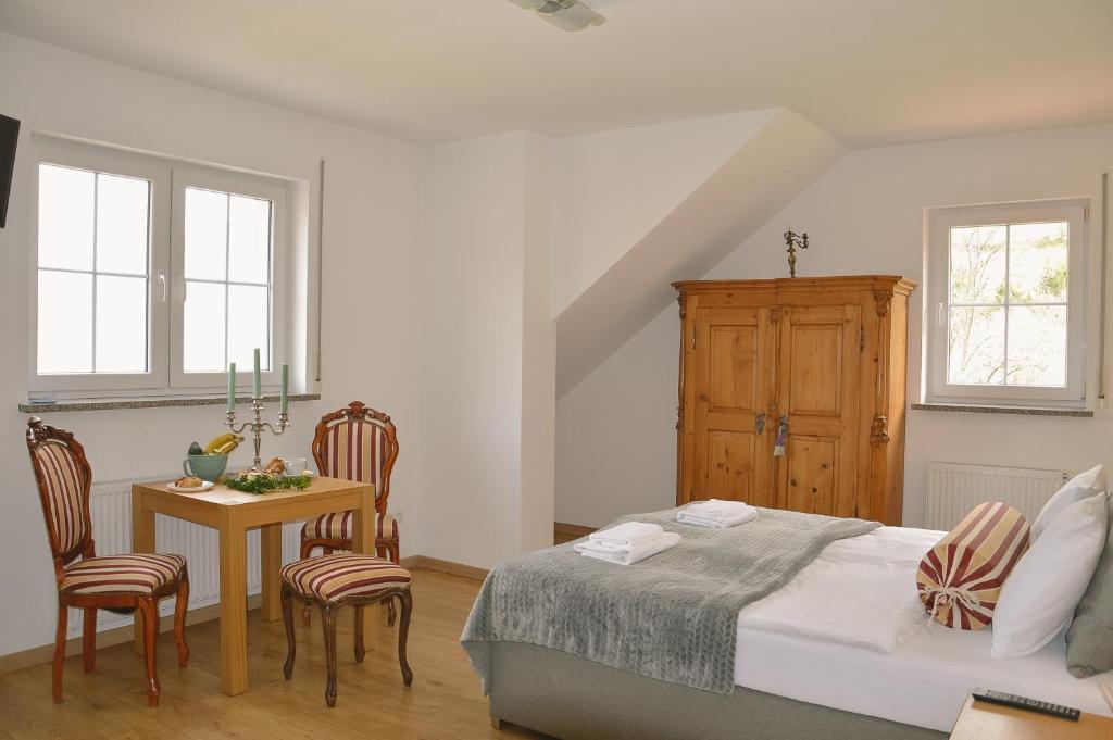 ein Schlafzimmer mit einem Bett und einem Tisch und Stühlen in der Unterkunft Apartamenty Agroturystyczne Papiernia in Niedźwiedź