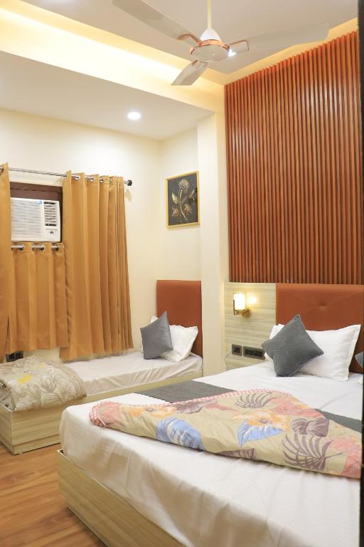 a hotel room with two beds and a fan at Amritsar view new hotel near golden temple in Amritsar