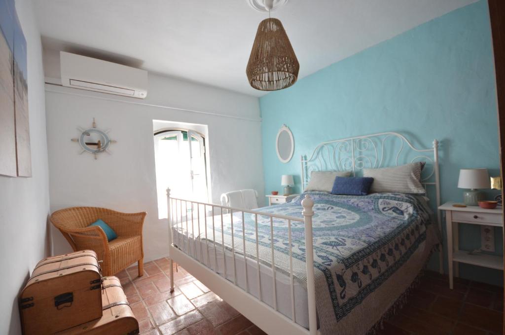 a bedroom with a bed with a blue wall at Casa Fernanda in Fuzeta