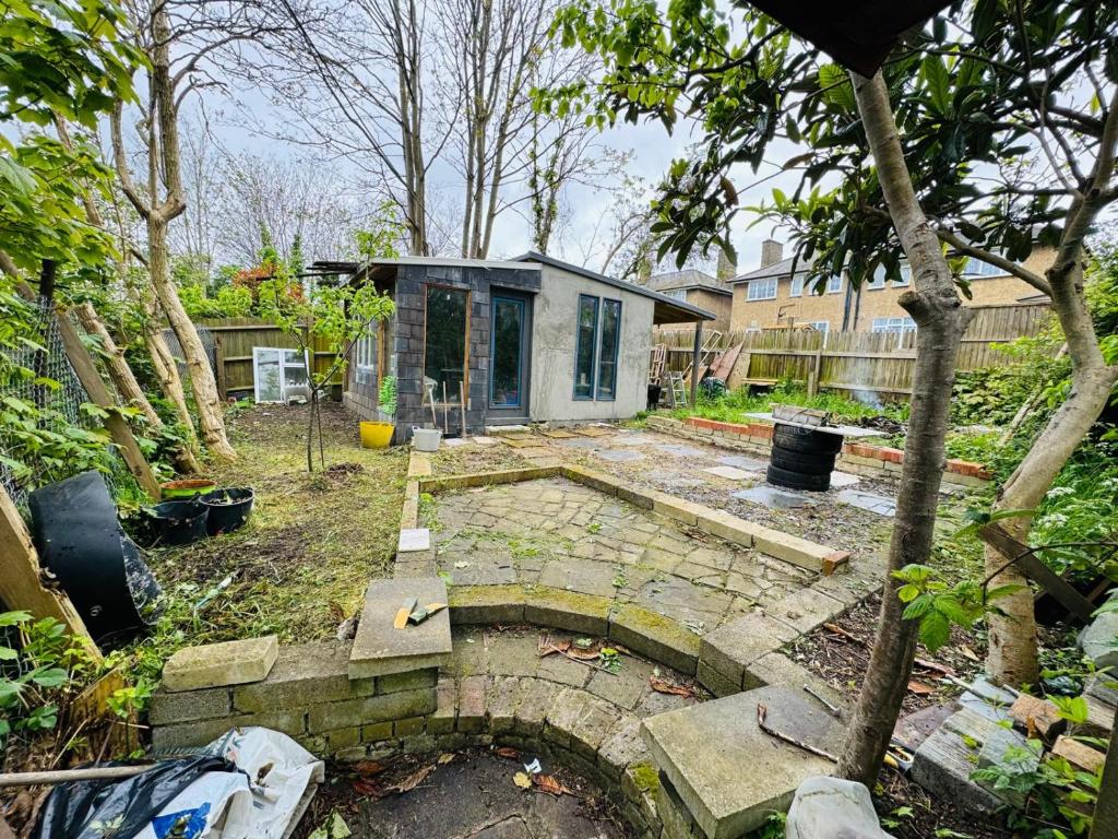 a backyard with a tiny house in a yard at 3 bed West Norwood Apartment in West Dulwich