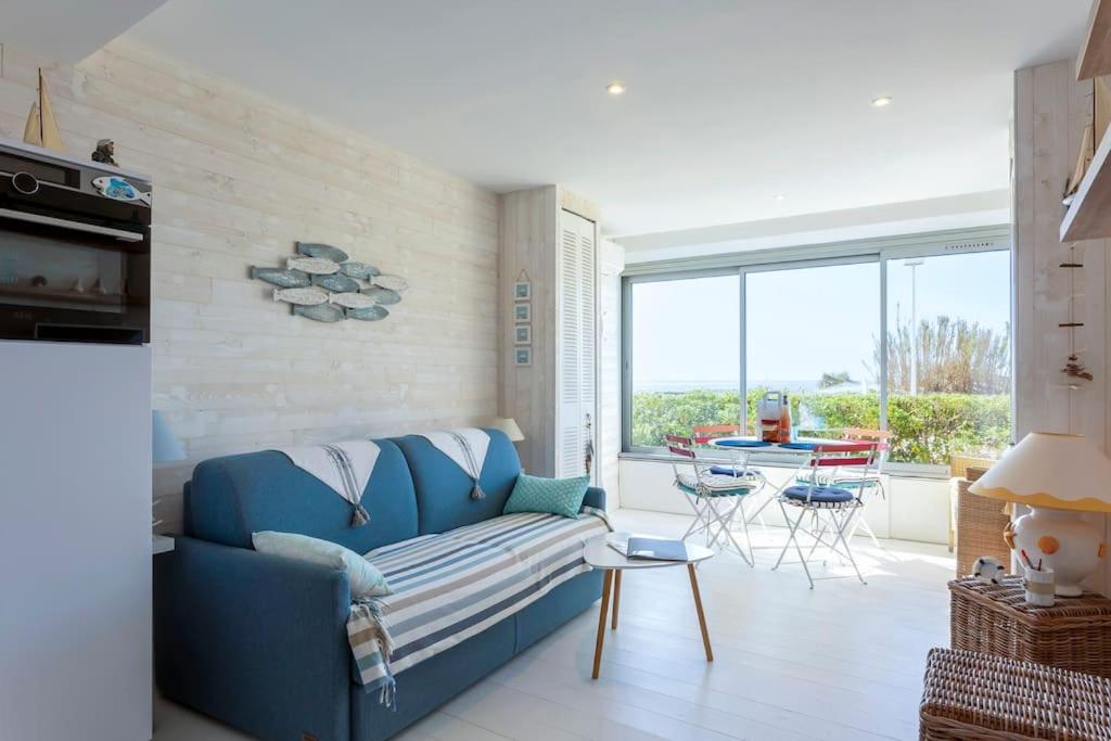un salon avec un canapé bleu et une table dans l'établissement Chez Danièle - Superbe studio avec une vue mer exceptionnelle, à La Grande Motte
