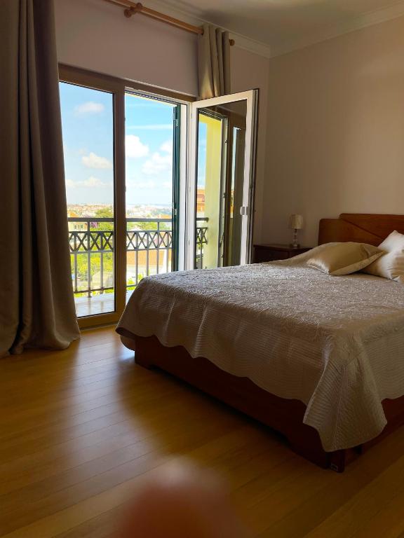 a bedroom with a bed and a view of a balcony at Lolik Villa in Sobreda