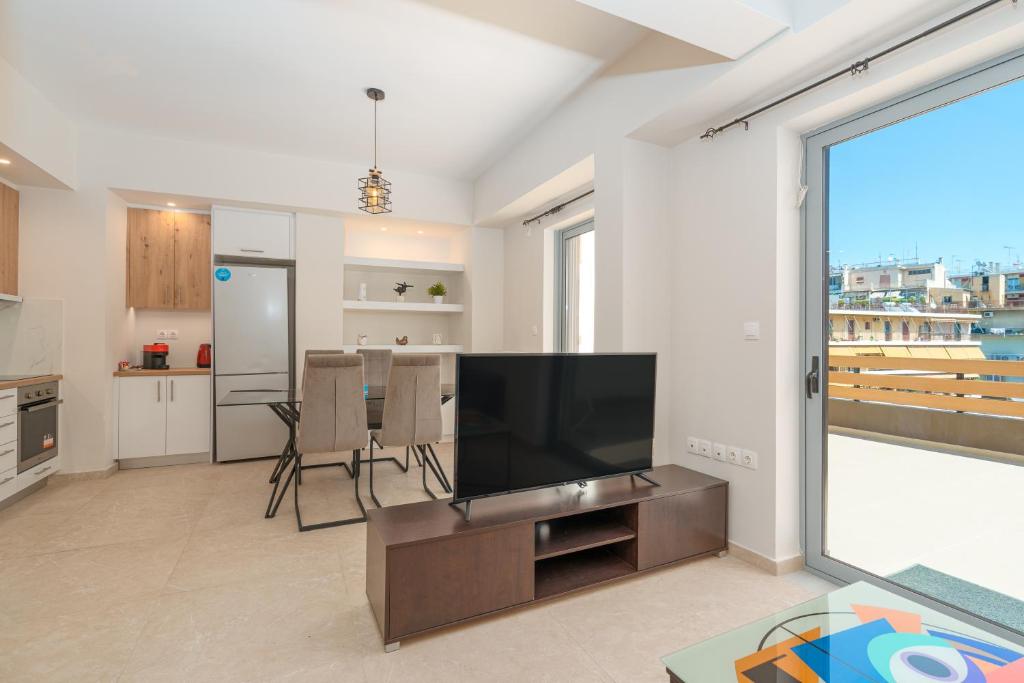 a living room with a television and a large window at Luxury penthouse near Acropolis in Athens