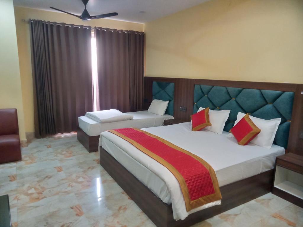 sypialnia z łóżkiem, krzesłem i oknem w obiekcie Amigo Rooms w mieście Rishikesh