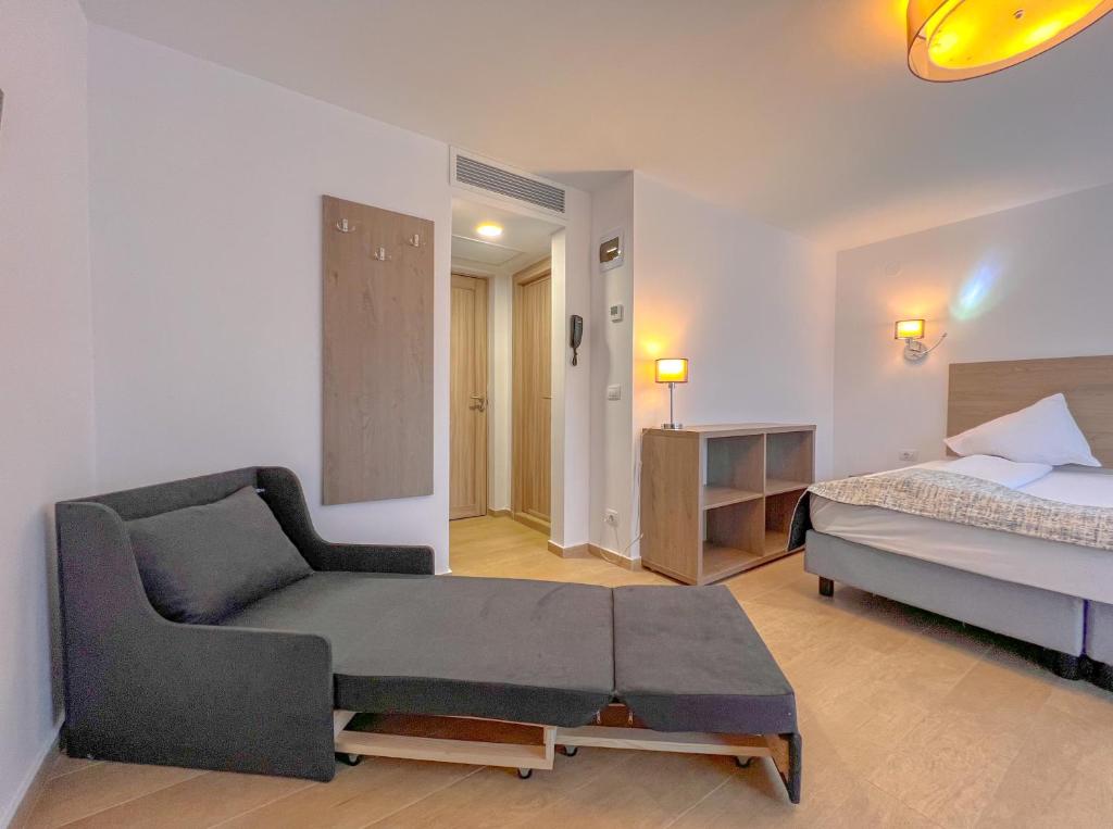 - une chambre avec un lit et un canapé dans l'établissement Aurora Rooms - 290m from Aqua Park, à Băile Olăneşti