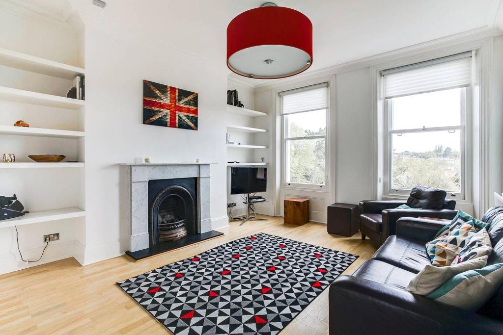 a living room with a couch and a fireplace at GuestReady - Beautiful Home in Wimbledon Village in London
