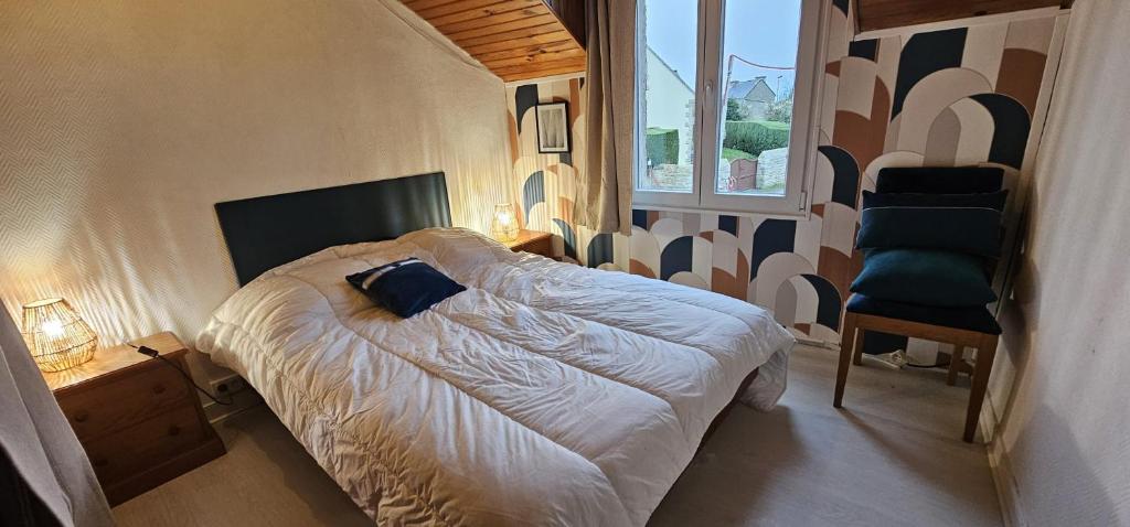 ein Schlafzimmer mit einem Bett, einem Stuhl und einem Fenster in der Unterkunft Maison Bretagne in Saint-Jacut-de-la-Mer