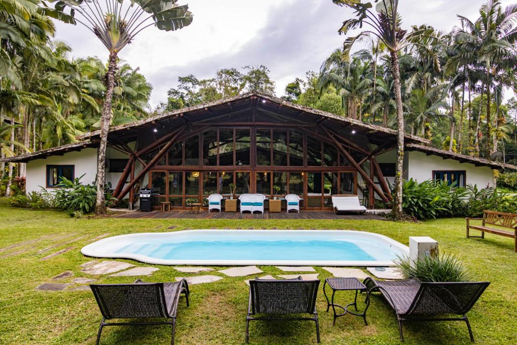 安格拉杜斯雷斯的住宿－paraíso tropical exótico, natureza e mar, golfe e marina，前面有游泳池的房子