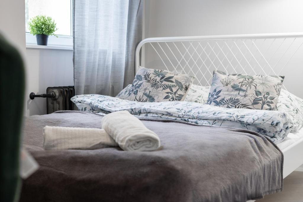 uma cama com um cobertor e almofadas em 33 Gdynia Oksywie - Apartament Mieszkanie dla 2 os em Gdynia