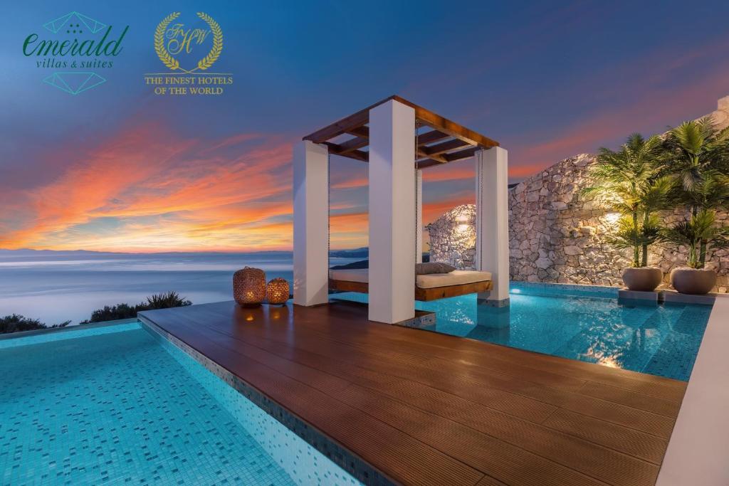 a luxury villa with a infinity pool at sunset at Emerald Villas & Suites - The Finest Hotels Of The World in Agios Nikolaos