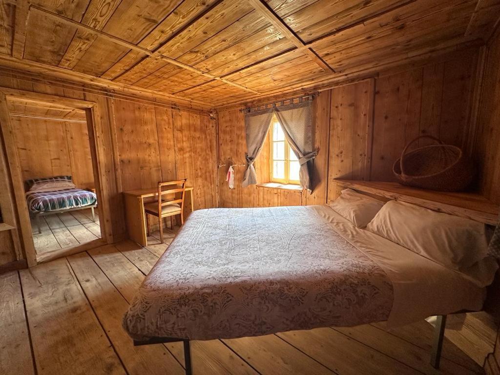 a bedroom with a bed in a wooden cabin at Rifugio Teggiate in Madesimo