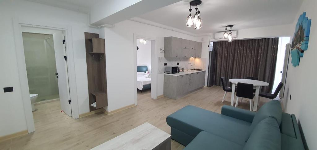 Il comprend un salon avec un canapé bleu et une cuisine. dans l'établissement Infinity Aparthotel & Spa Resort Prima Linie la Mare, Piscina Infinity la Etaj 11 Panorama, à Mamaia Nord – Năvodari