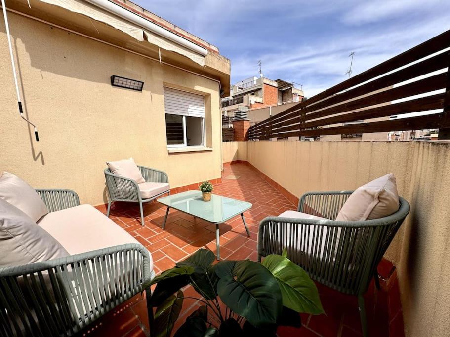 um pátio com 2 cadeiras e uma mesa na varanda em House with terrace connected with Downtown&Airport em Barcelona