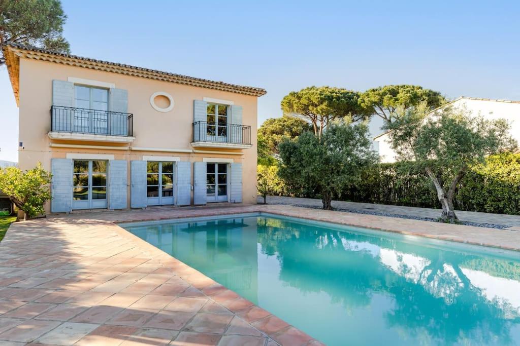 une villa avec une piscine en face d'une maison dans l'établissement Magnifique Villa avec piscine et hammam, à Saint-Tropez