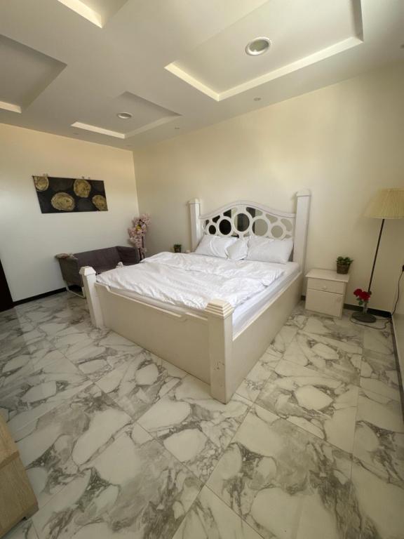 a bedroom with a white bed and a marble floor at استديو in Unayzah