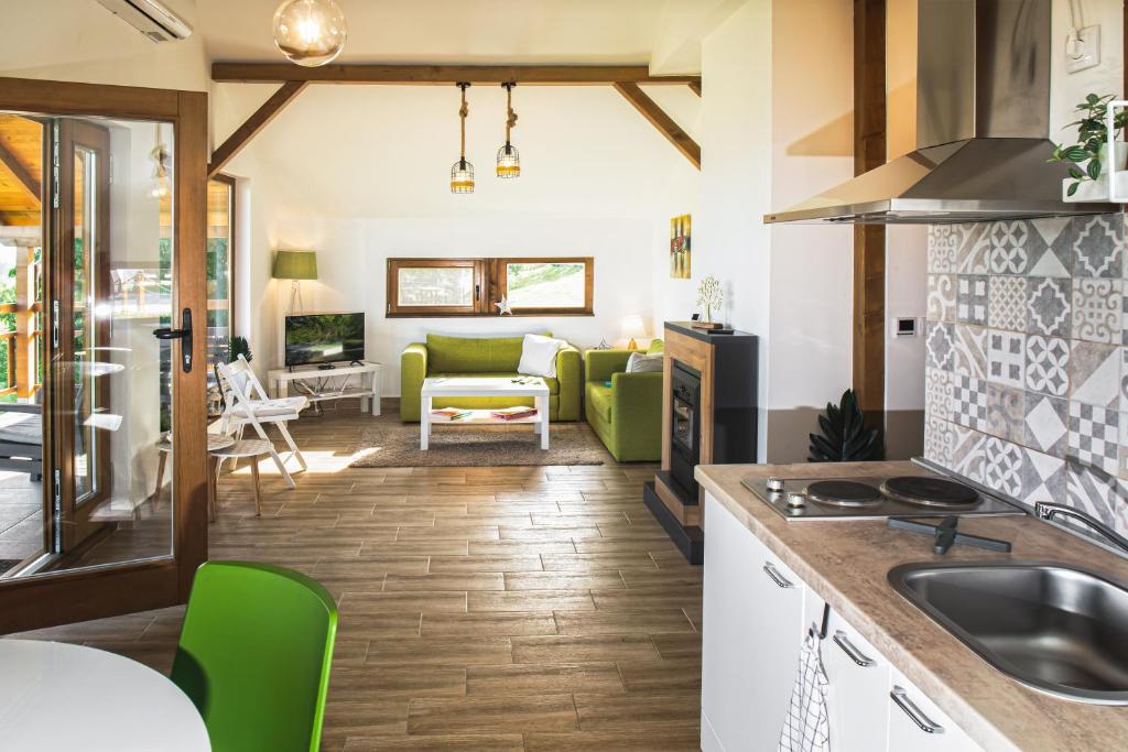 a kitchen and living room with green chairs at LIPA houses & spa in Sopot