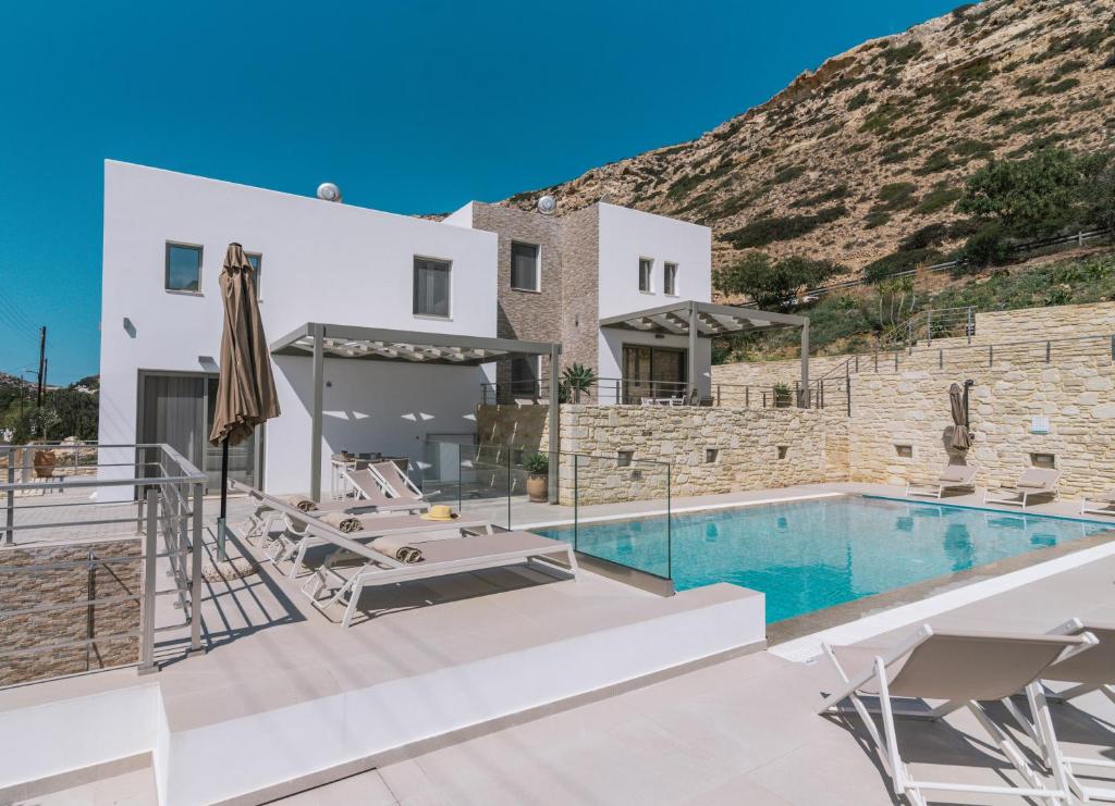 une villa avec une piscine et une montagne dans l'établissement Matala Prime Villas, à Matala