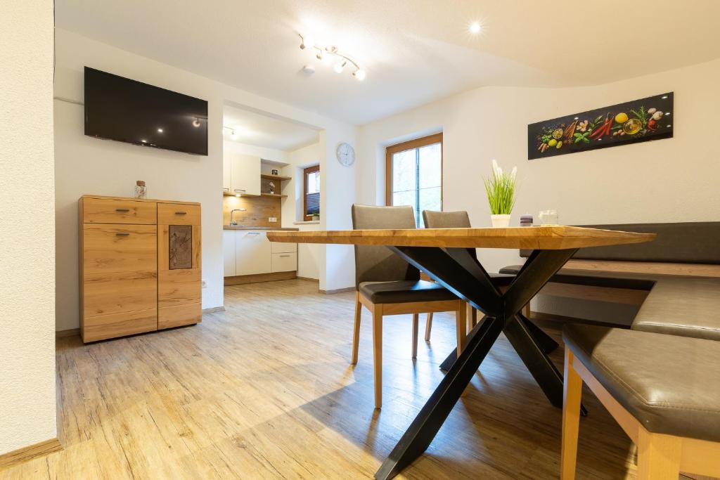 a dining room with a table and a kitchen at Appartment Klaus in Zellbergeben