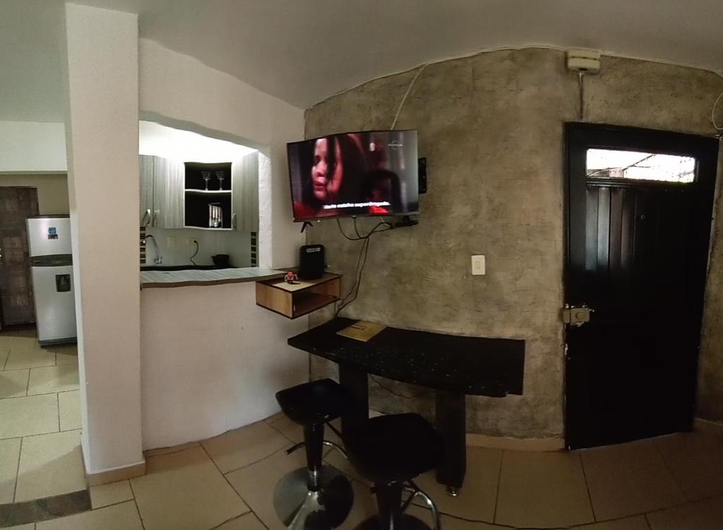 a living room with a table and a tv on a wall at descanso in Medellín