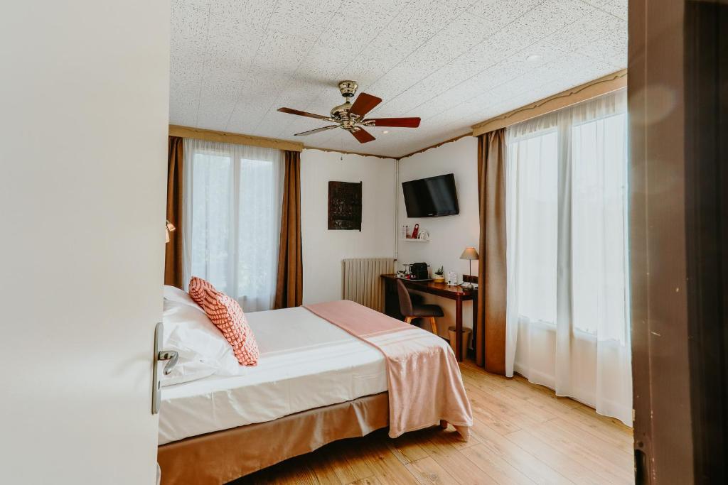 a bedroom with a bed and a ceiling fan at Hôtel L&#39;Iroko The Originals City in Aix-les-Bains