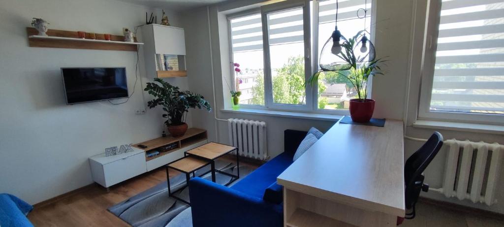 a living room with a table and blue chairs at R&J Apartment II in Panevėžys