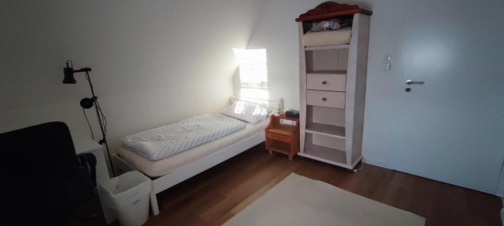 a small bedroom with a small bed and a dresser at Haus am Park in Steinhagen