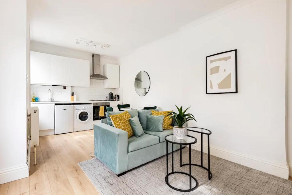 uma sala de estar com um sofá azul e uma mesa em Stylish one bedroom apartment in Greater London em Londres