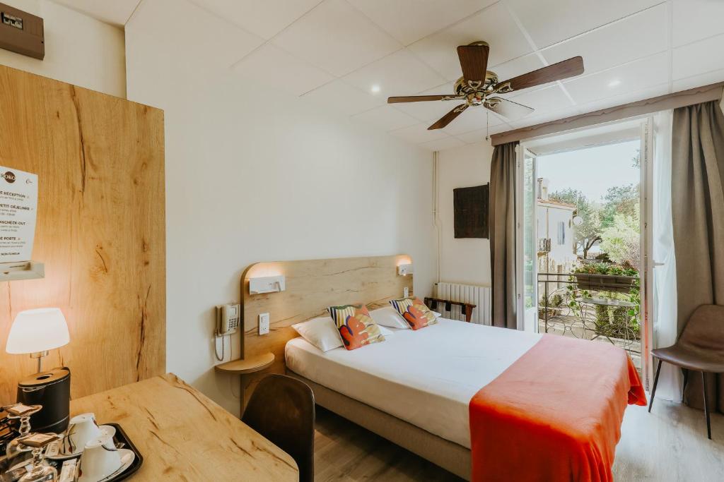 a hotel room with a bed and a window at Hôtel L&#39;Iroko The Originals City in Aix-les-Bains