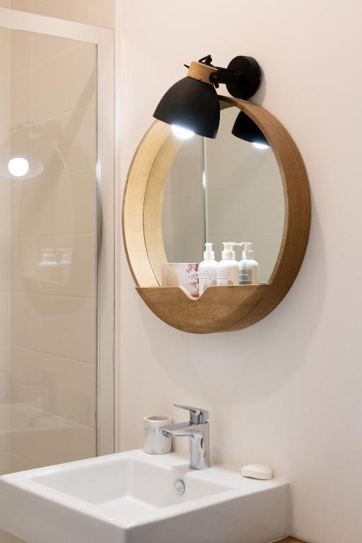 Baño con espejo sobre un lavabo en Le Terrazzo - appartement lumineux centre Eu, en Eu