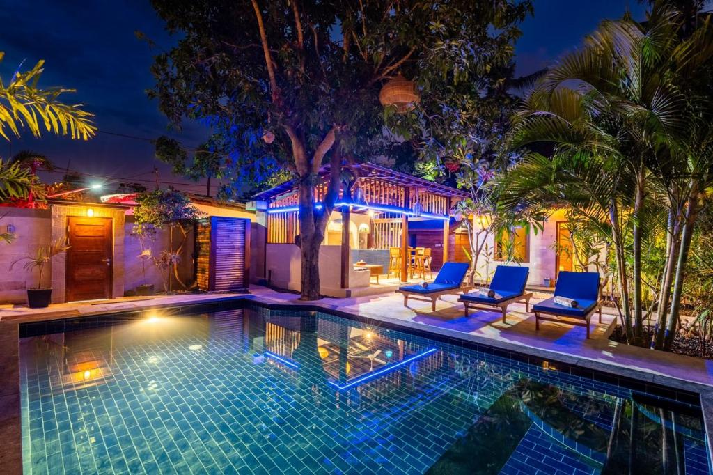 Paradise Luxury Villa في غيلي آير: مسبح مع كرسيين ازرق ومنزل