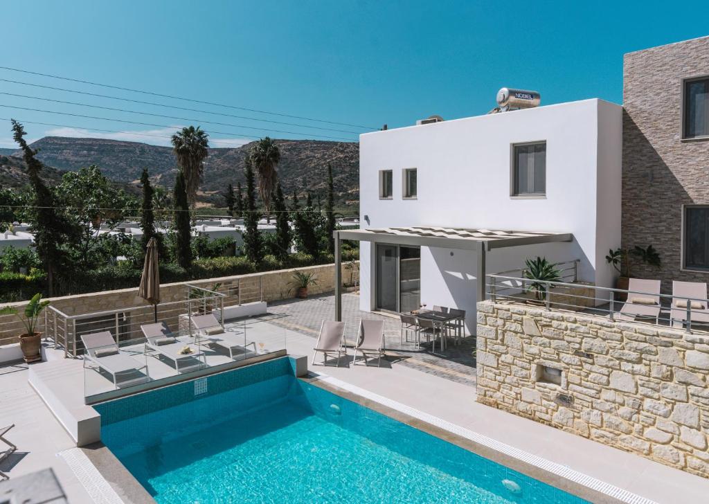 a villa with a swimming pool and a house at Matala Prime Villas in Matala
