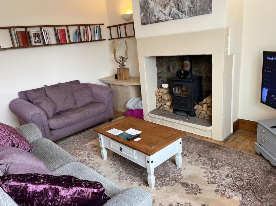 a living room with a couch and a fireplace at Steeple View - A two bedroom 18th century cottage. in Leeds
