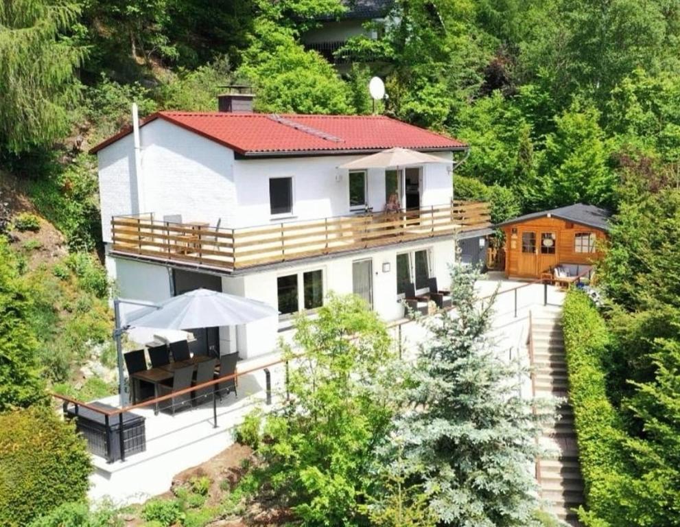 ein großes weißes Haus mit einer Terrasse und einem Balkon in der Unterkunft diemelseeholiday Ferienwohnung am Diemelsee mit Balkon in Diemelsee