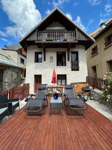una terraza con sillas, una mesa y un edificio en Chalet Pitu en Vénosc
