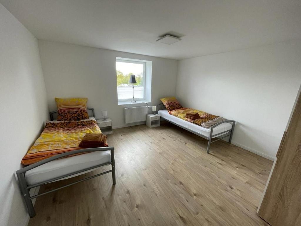 Duas camas num quarto com uma janela em Gemütliches Doppelzimmer in Schleswig-Holstein - ideal für Monteure und Geschäftsreisende, Gemeinschaftsbad Zimmer Nr 5 em Groß Vollstedt