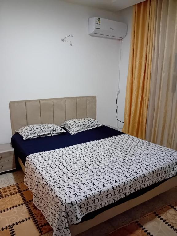 um quarto com uma cama com um edredão preto e branco em Asma em Houmt Souk