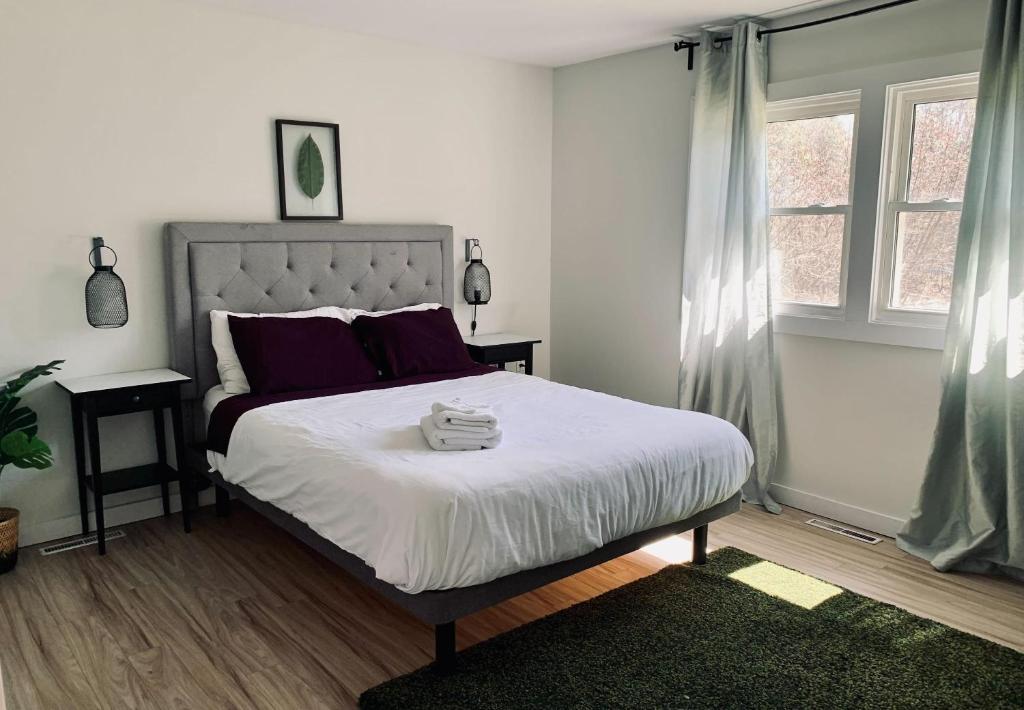 a bedroom with a large bed with purple pillows at Serene Cottage in Halifax