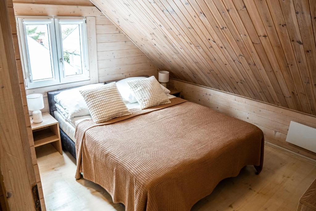 a bedroom with a bed in a wooden room at Collins Beach in Ustronie Morskie