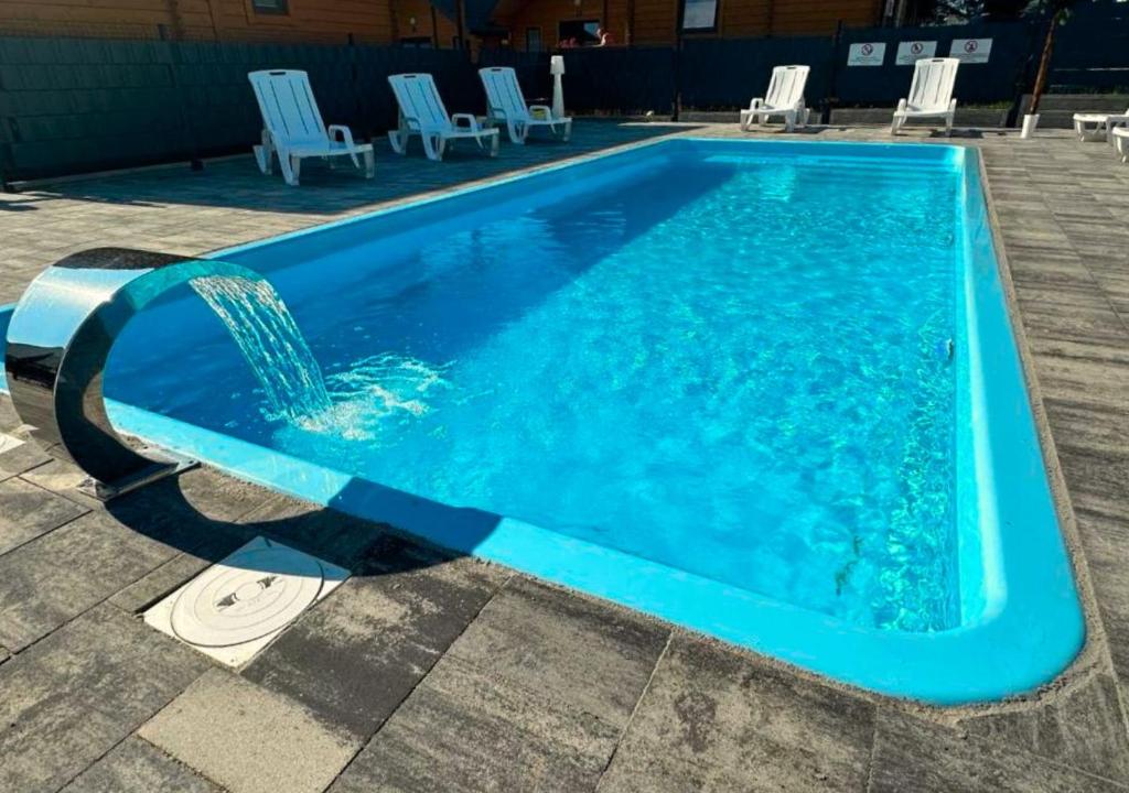 una piscina azul con una fuente de agua en Ośrodek Wczasowy Kuba, en Jarosławiec