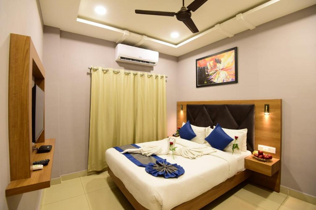 a bedroom with a large bed with blue pillows at Click Hotel Guwahati in Guwahati