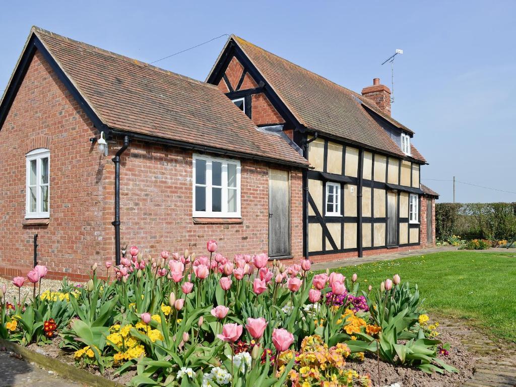 uma casa com um ramo de flores à frente dela em Bank Cottage em Boraston