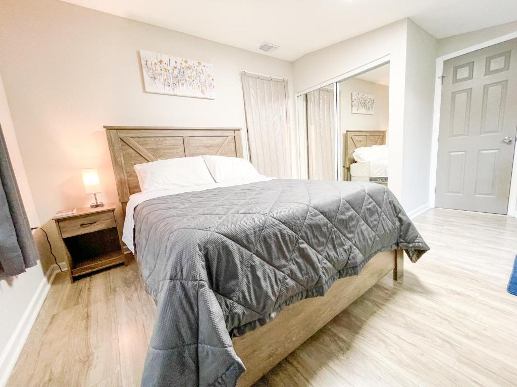 Un dormitorio con una cama grande y una mesa con una lámpara. en Beautiful room in prime location, en Pinellas Park