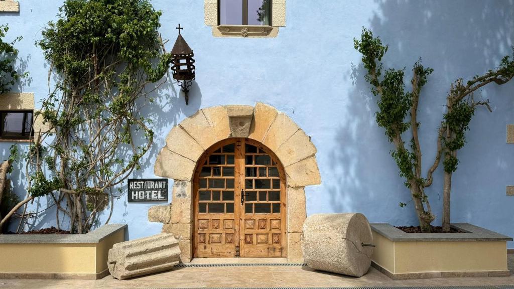 a building with a door with a sign on it at AlliOli Boutique Hotel Spa in Castelló d'Empúries