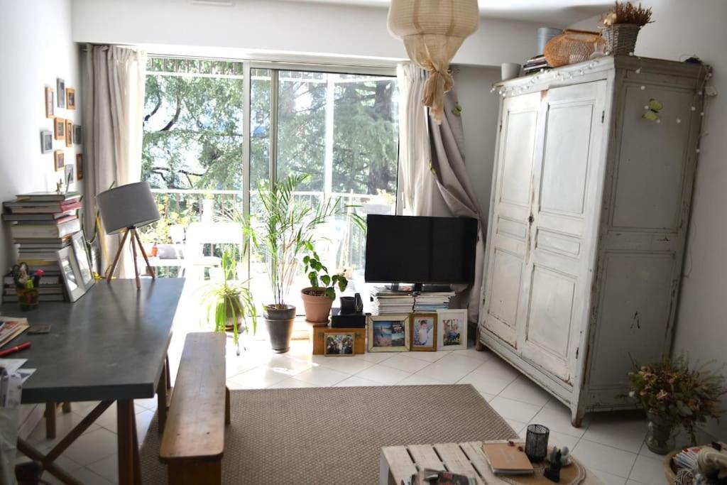 un salon avec une télévision et une grande fenêtre dans l'établissement Appartement super clair, à Nice