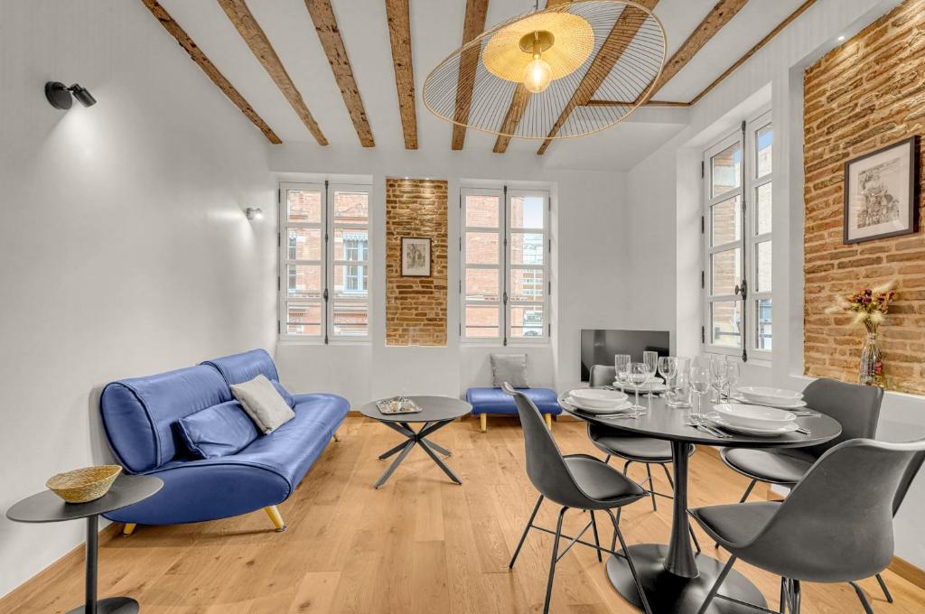 un salon avec un canapé bleu et une table dans l'établissement Frère Jacques - Appt situé plein centre, à Toulouse