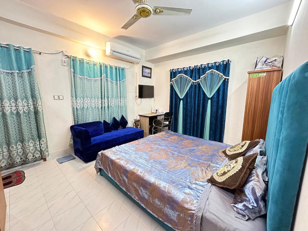 um quarto com uma cama e uma cadeira azul em ASIF's Residence In Newmarket em Daca