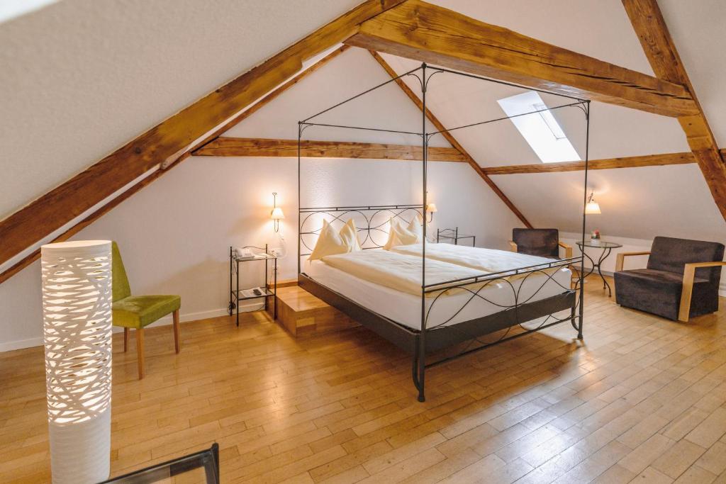 a bedroom with a canopy bed in a attic at ODELYA Hotel & Naturgarten Basel City in Basel